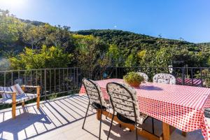 a table and chairs on a deck with a view of a mountain at Apartmani Valun1 in Valun