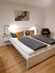 een groot wit bed in een kamer met een stoel bij Ferienwohnung Hildegard Eiter in Sankt Leonhard im Pitztal
