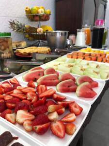 a tray of strawberries and apples on a table at Shallom Hotel in Balneário Camboriú