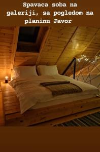 a large bed in a room with a wooden ceiling at Cortina resort in Ivanjica
