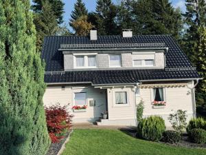 una casa blanca con techo negro en Bergstadthütte Harz en Bad Grund