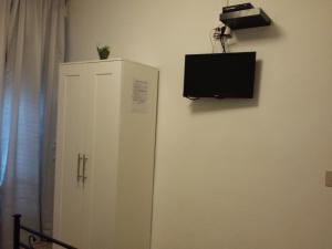 a white cabinet with a television on a wall at Casa Giulia in Pisa