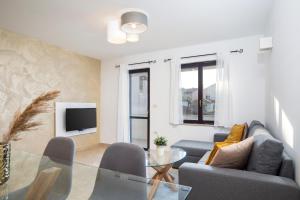 salon z kanapą i szklanym stołem w obiekcie Sandy Bay Apartments - free mountainbike rental - w mieście Pješčana Uvala