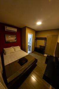 バウネアーリオ・コンボリウーにあるBonabrigo Hostel & Suítesの赤い壁のベッドルーム1室