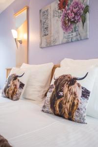 a bed with two bull pillows on it at Hotel Kiepenkerl in Winterberg