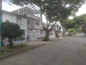 eine leere Straße vor einem weißen Haus in der Unterkunft Alcobas cerca al Éxito San Fernando in Cali