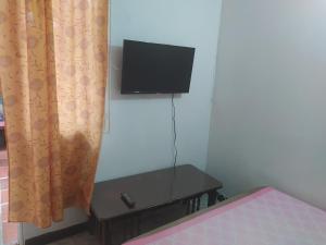 ein Schlafzimmer mit einem Bett und einem Fernseher an der Wand in der Unterkunft Alcobas cerca al Éxito San Fernando in Cali