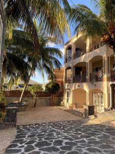 a large building with a palm tree in front of it at Villa Palmistes Apartment in La Gaulette