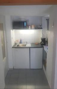 una piccola cucina bianca con lavandino e bancone di petit studio pour une personne à Lobsann a Lobsann