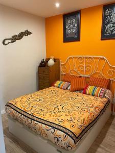 1 dormitorio con 1 cama con pared de color naranja en Llançà piso muy tranquillo Llança appartement très tranquille Llançà flat very calm, en Llançà