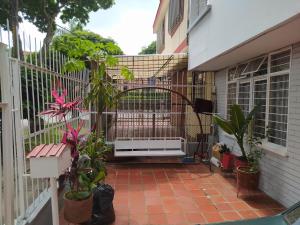 eine Terrasse mit Pflanzen und einem Zaun mit einer Heizung in der Unterkunft Alcobas cerca al Éxito San Fernando in Cali + 16 Fotos