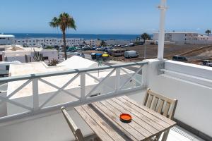 a wooden bench on a balcony with a view of the ocean at Los Panelos A2 A3 in Puerto del Carmen