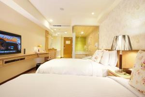 台北的住宿－長富時尚旅店，酒店客房设有两张床和一台平面电视。