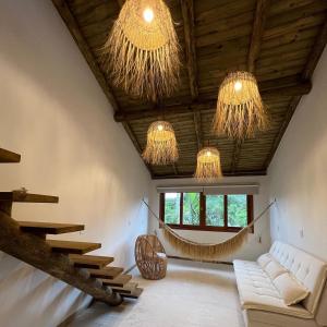 a living room with a hammock hanging from the ceiling at Pousada Vila Piola in Guarda do Embaú