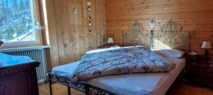 a bedroom with a bed in a wooden wall at CASA PAMPEAGO - Sulle piste da sci del Latemar in Tesero