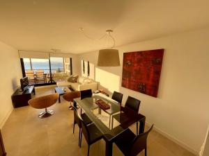 uma sala de estar com uma mesa e cadeiras e um sofá em Quartier Punta Ballena 2 dorm en suite em Punta del Este