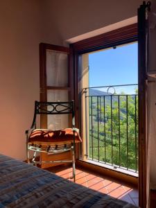 ein Schlafzimmer mit einem Bett und einem großen Fenster in der Unterkunft Agriturismo i Gessi in Calvignano