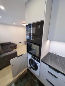 a kitchen with a microwave and a washer and dryer at Tammsaare Luxury Apartment in Pärnu