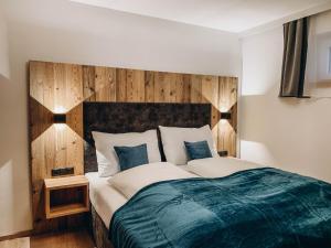 a bedroom with a large bed with a wooden headboard at FOUR PEAKS Apartment in Flachau