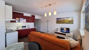 a living room with a couch and a kitchen at Apartmany Tilia in Nová Lesná
