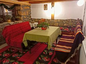 ein Wohnzimmer mit einem Tisch und einem Sofa in der Unterkunft NAXI GUEST HOUSE in Perućac