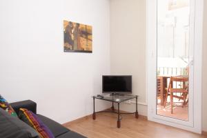 a living room with a tv on a glass table at Centric Apartment El Molino Theater p1 in Barcelona