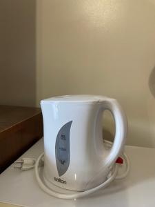 Una taza de café blanca sentada sobre un mostrador en Mountain View Motel en Smithers