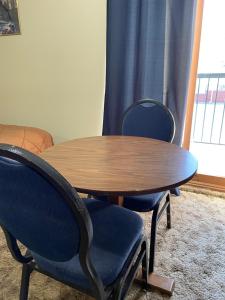 uma mesa de madeira e duas cadeiras e uma mesa e uma janela em Mountain View Motel em Smithers