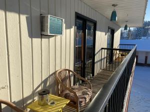 einen Balkon mit einem Tisch und Stühlen auf einem Gebäude in der Unterkunft Mountain View Motel in Smithers
