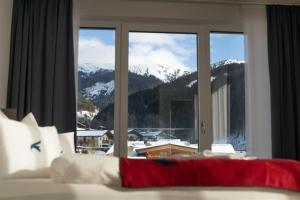 a bedroom with a view of a mountain through a window at Falcon Suites Zell am See in Zell am See