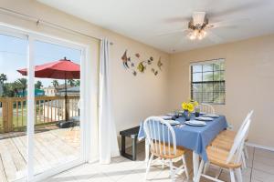 a dining room with a blue table and chairs at House of Neptune Steps from the sea and private pool in South Padre Island