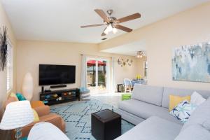 uma sala de estar com um sofá e uma televisão de ecrã plano em House of Neptune Steps from the sea and private pool em South Padre Island