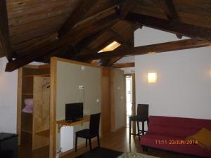 Una sala de estar con techos de madera y un sofá rojo. en Hotel Boa Vila, en Pontevedra