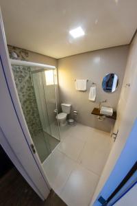 a bathroom with a glass shower and a toilet at Bonabrigo Hostel & Suítes in Balneário Camboriú