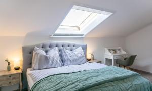 a bedroom with a large bed with a skylight at Sonnig, Balkon, Berge & im Herzen von Sonthofen JS1 in Sonthofen