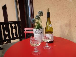 Una botella de vino y dos copas en una mesa. en La Lonzagne, en Peisey-Nancroix