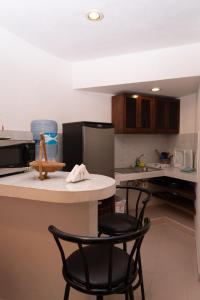 a kitchen with two black chairs and a counter at Casa Bonita and villas in Isla Mujeres