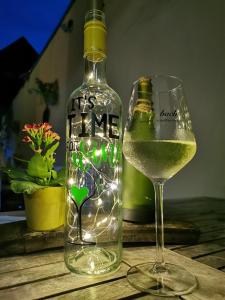 una botella de vino y una copa en una mesa en Weingut Gästehaus Bach en Cochem
