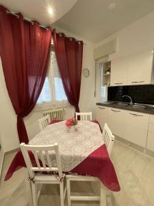 eine Küche mit einem Tisch und einem roten Vorhang in der Unterkunft Alice sweet home in Corsico