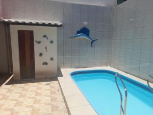 a swimming pool with a dolphin on the wall at POUSADA BEIRUTE in Cabo Frio
