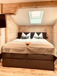 a bedroom with a large bed with a skylight at Pension Kreuzeck - Dein Glücksplatz am Lech in Weissenbach am Lech