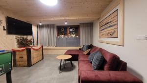- un salon avec un canapé et une table dans l'établissement Willa Kozincówka, à Zakopane
