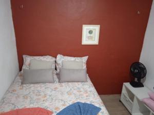 a bedroom with a bed with a red wall at Casa da Fernanda in Guaramiranga