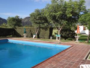 una piscina de agua azul en un patio en Hotel Lujan en Luján