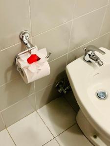 a bathroom with a toilet paper dispenser with a red rose at Hotel Cristallo Gran Sasso in LʼAquila