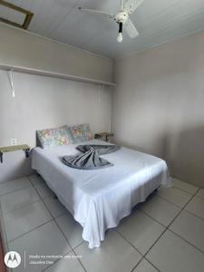 a bedroom with a bed with a blanket on it at Pousada Belas Praia - Ribanceira in Imbituba