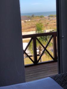 a room with a view of the ocean from a balcony at Punta del Este San Marcos Eco Hotel in Punta del Este