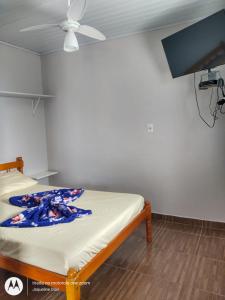 a bed in a room with a ceiling fan at Pousada Belas Praia - Ribanceira in Imbituba