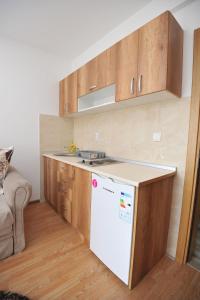 uma cozinha com um frigorífico branco e armários de madeira em Kopaonik Apartman Sanja em Kopaonik