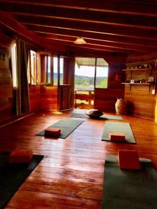 Habitación con esterillas de yoga en el suelo de madera. en Del Sol a la Montaña EcoLodge - Turismo Consciente in 